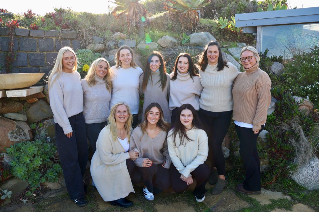 Embellish Beauty staff retreat. Ten females in beige tops and black pants gathered together